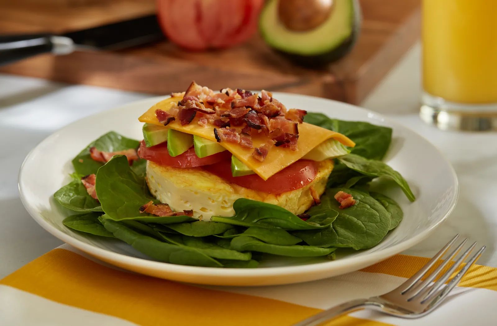 Naked Nellie: egg topped with tomato, avocado, cheddar and bacon on spinach.